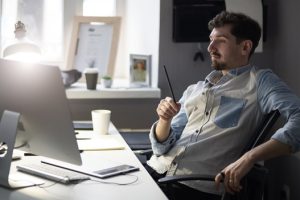 employee sitting behind his computer thinking